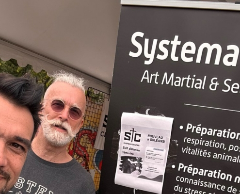 Trois membres du Systema Centre au stand du club, place du Martroi, devant le kakémono présentant l’art martial et la self-défense