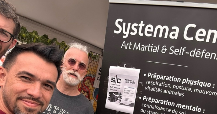Trois membres du Systema Centre au stand du club, place du Martroi, devant le kakémono présentant l’art martial et la self-défense